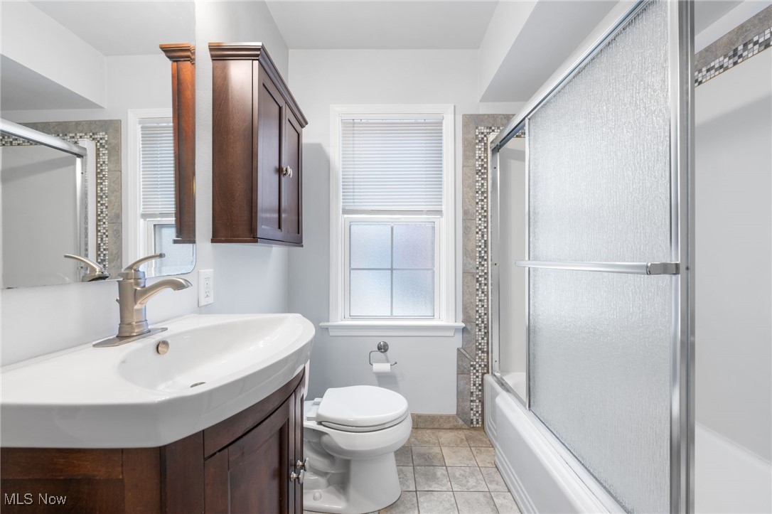 1704 Lyndhurst Road Lyndhurst, OH 44124 - Photo 16 of 35 Full bathroom featuring tile patterned flooring, vanity, enclosed tub / shower combo, and toilet