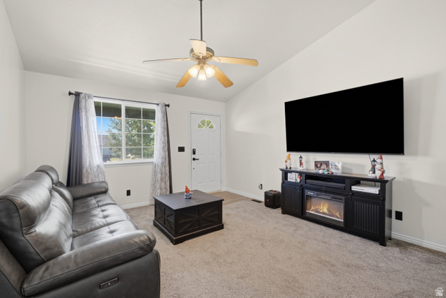2135 East White Pine Road Eagle Mountain, UT 84005 - Photo 3 of 23 Living area featuring vaulted ceilings, a ceiling fan with light kit, a large picture window, and a built-in electric fireplace media console