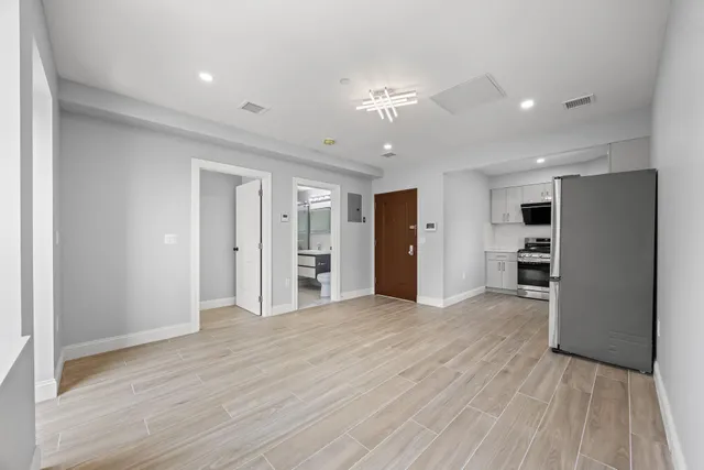 a view of empty room with wooden floor