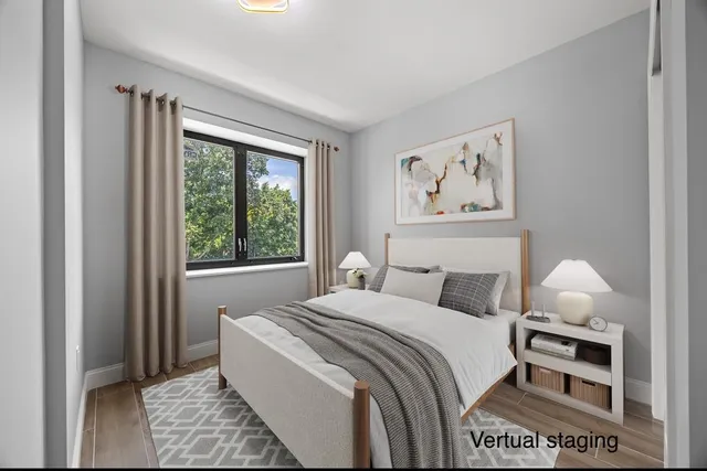 a bedroom with a bed a rug and a window