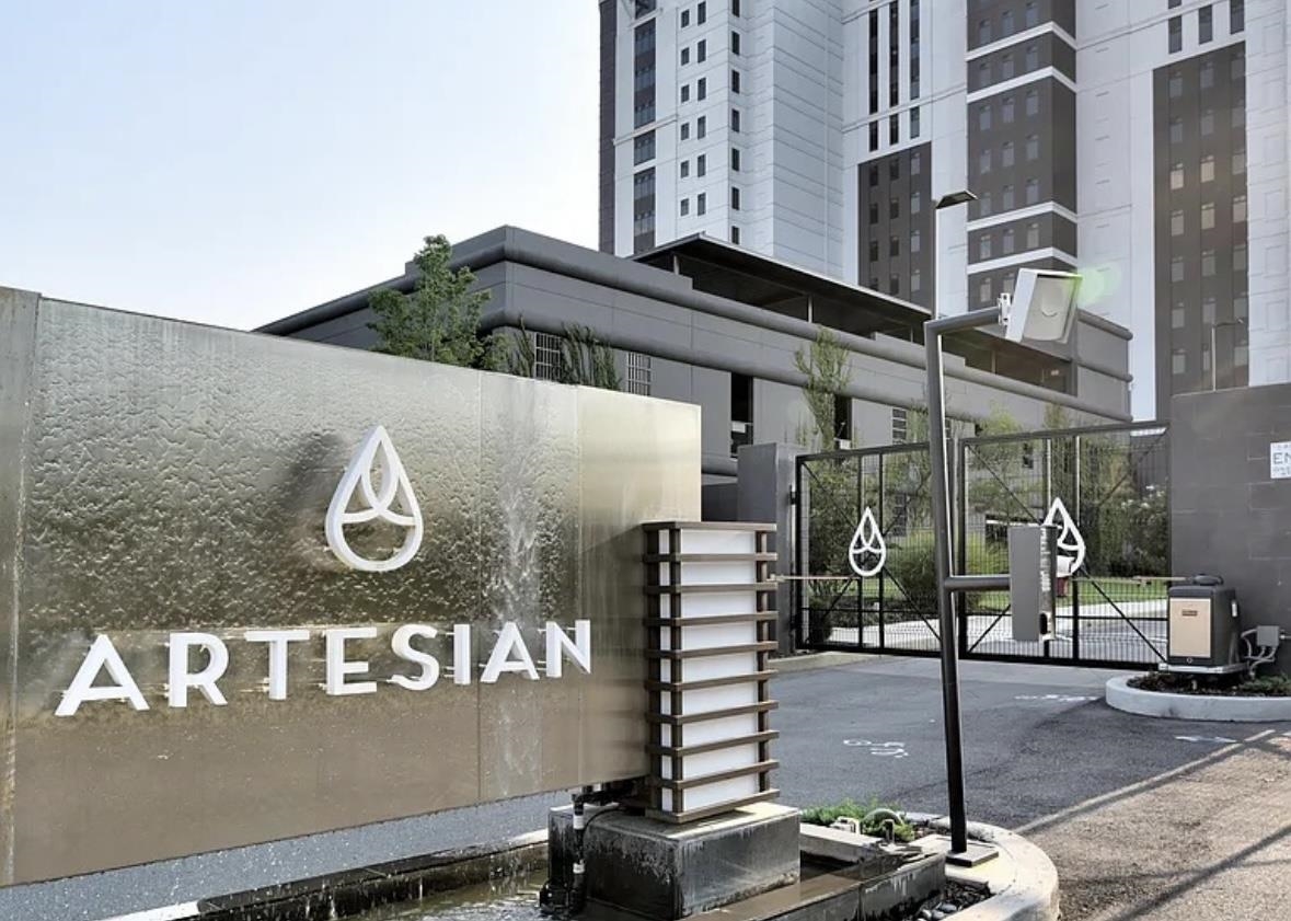 Community sign featuring fence and a gate