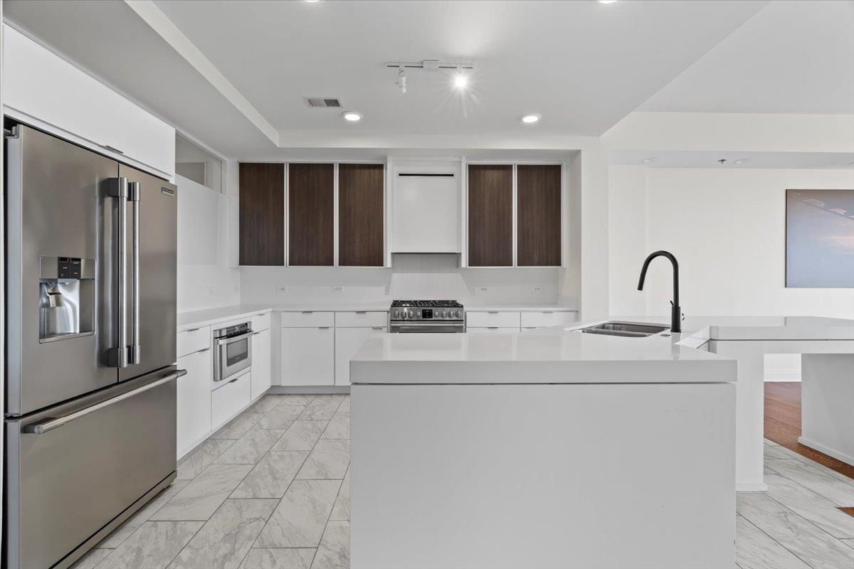 717 Riverside Drive, Unit 906 Memphis, TN 38103 - Photo 2 of 24 Kitchen with appliances with stainless steel finishes, marble finish floor, modern cabinets, and visible vents