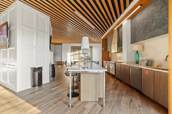 a kitchen with stainless steel appliances kitchen island granite countertop a table chairs and a refrigerator