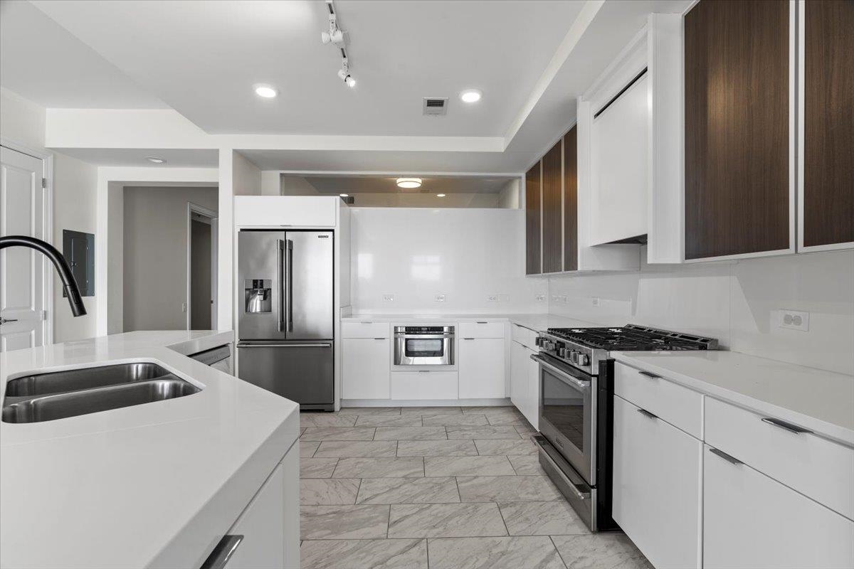 717 Riverside Drive, Unit 906 Memphis, TN 38103 - Photo 5 of 24 Kitchen with visible vents, a sink, light countertops, white cabinetry, and stainless steel appliances