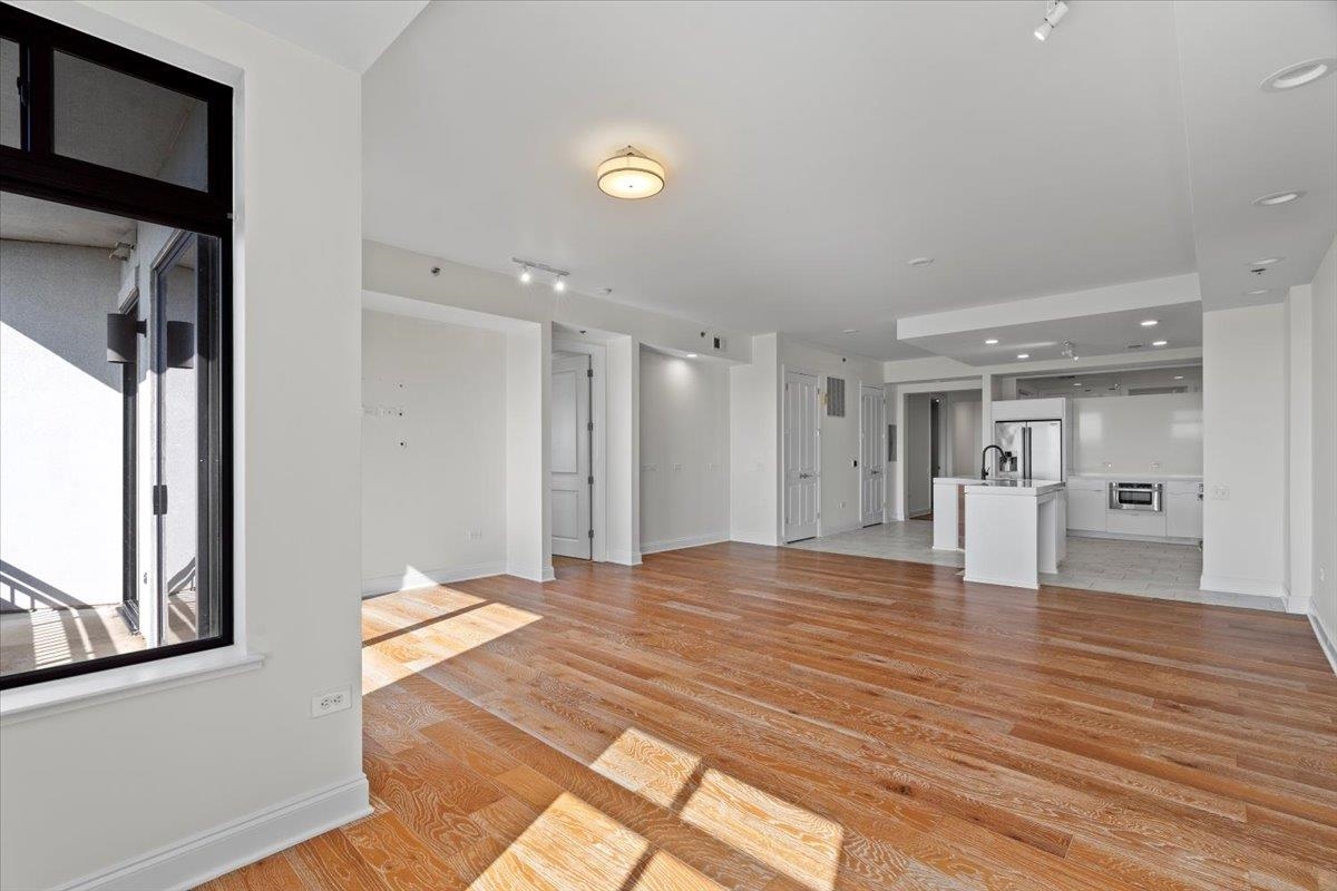 717 Riverside Drive, Unit 906 Memphis, TN 38103 - Photo 6 of 24 Unfurnished living room with a sink, light wood-type flooring, and baseboards