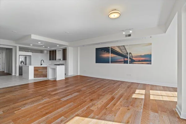 a view of a hallway with wooden floor and dining room