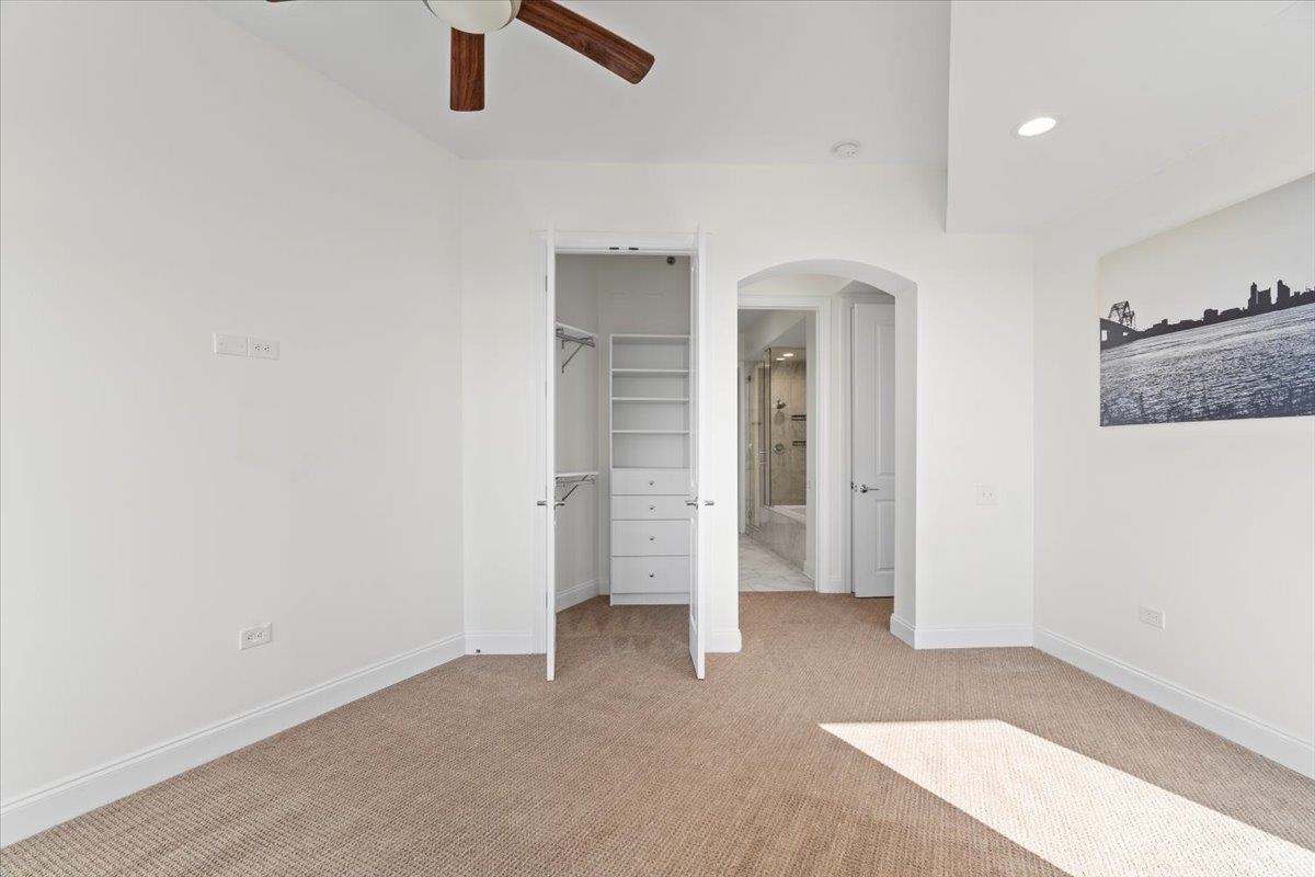 717 Riverside Drive, Unit 906 Memphis, TN 38103 - Photo 8 of 24 Unfurnished bedroom with arched walkways, light colored carpet, baseboards, and a spacious closet