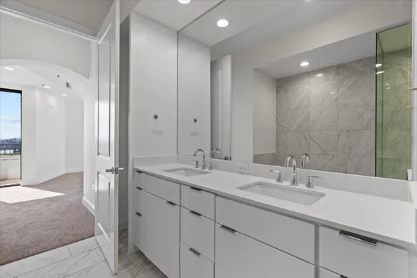 a bathroom with a double vanity sink mirror and shower