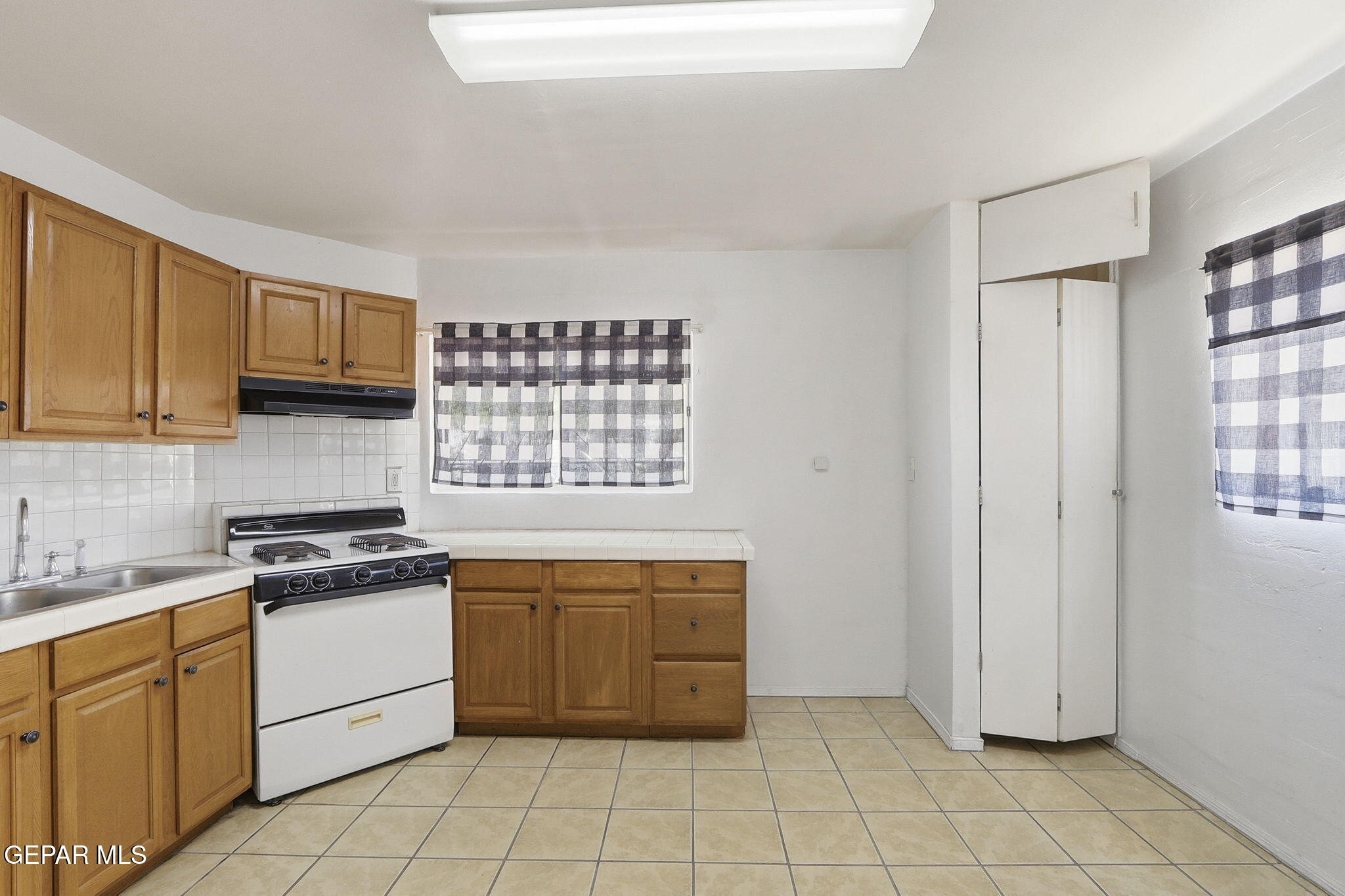 496 Telop Road El Paso, TX 79927 - Photo 11 of 12 a kitchen with granite countertop white cabinets and appliances