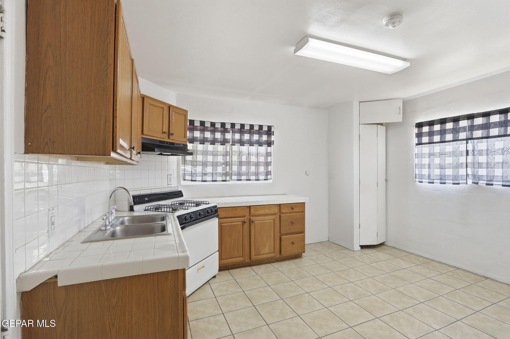 496 Telop Road El Paso, TX 79927 - Photo 10 of 12 a kitchen with granite countertop a sink stove top oven and cabinets