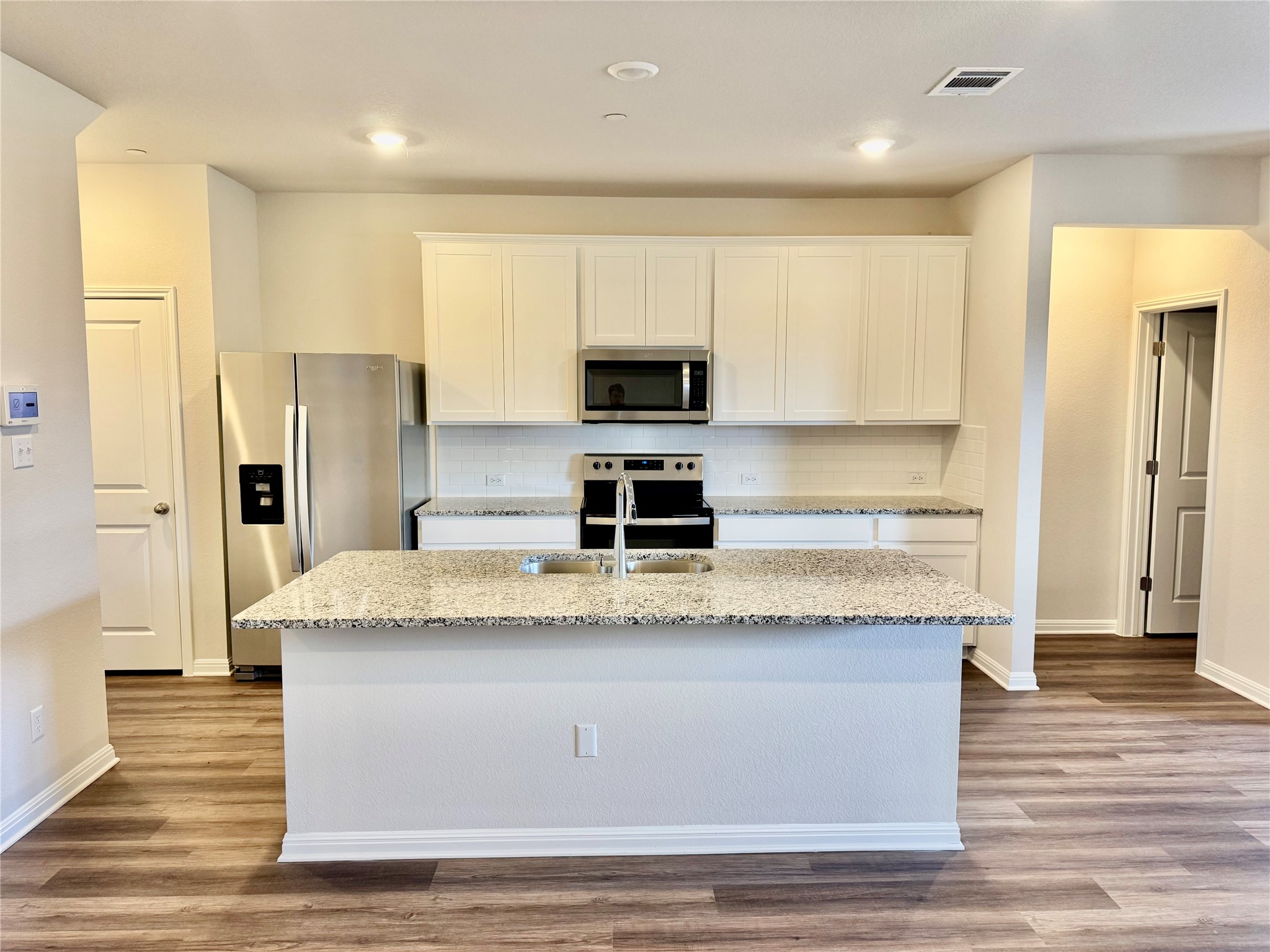 165 Calcite Road, Unit 2 Kyle, TX 78640 - Photo 2 of 17 a kitchen with granite countertop a refrigerator and a stove top oven