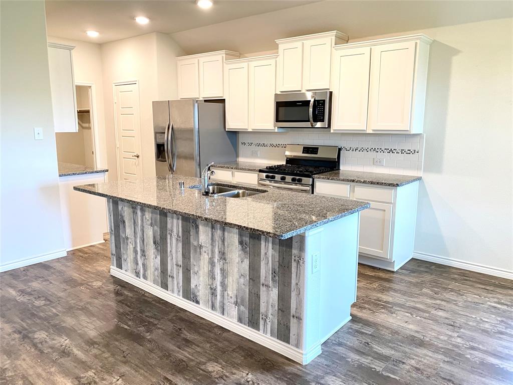 3600 Rio Grande Road Little Elm, TX 75068 - Photo 1 of 1 a kitchen with stainless steel appliances granite countertop a stove a refrigerator a sink a stove with wooden floor