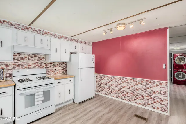 a kitchen with granite countertop a stove a refrigerator and a stove