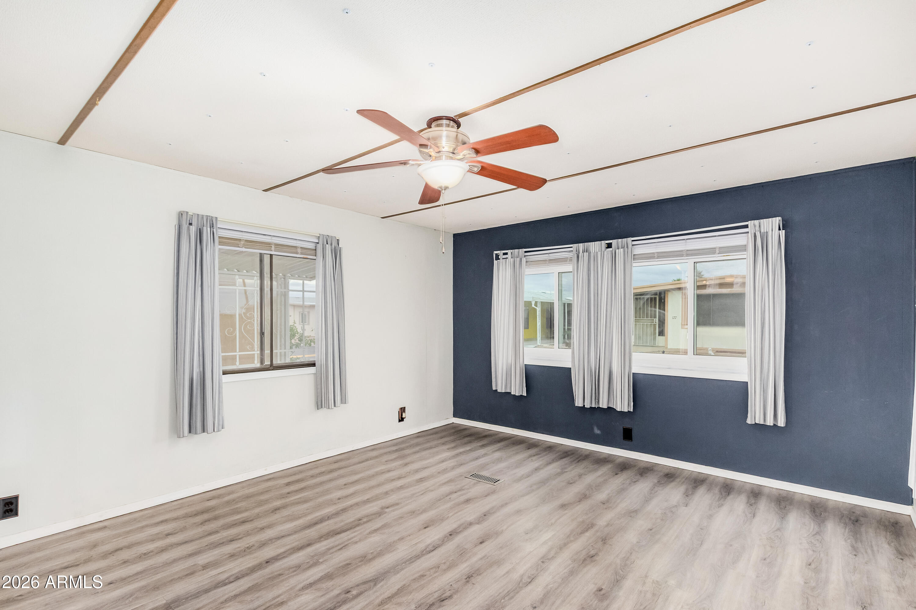 9302 East Broadway Road, Unit 122 Mesa, AZ 85208 - Photo 6 of 30 a view of an empty room with a window and wooden floor