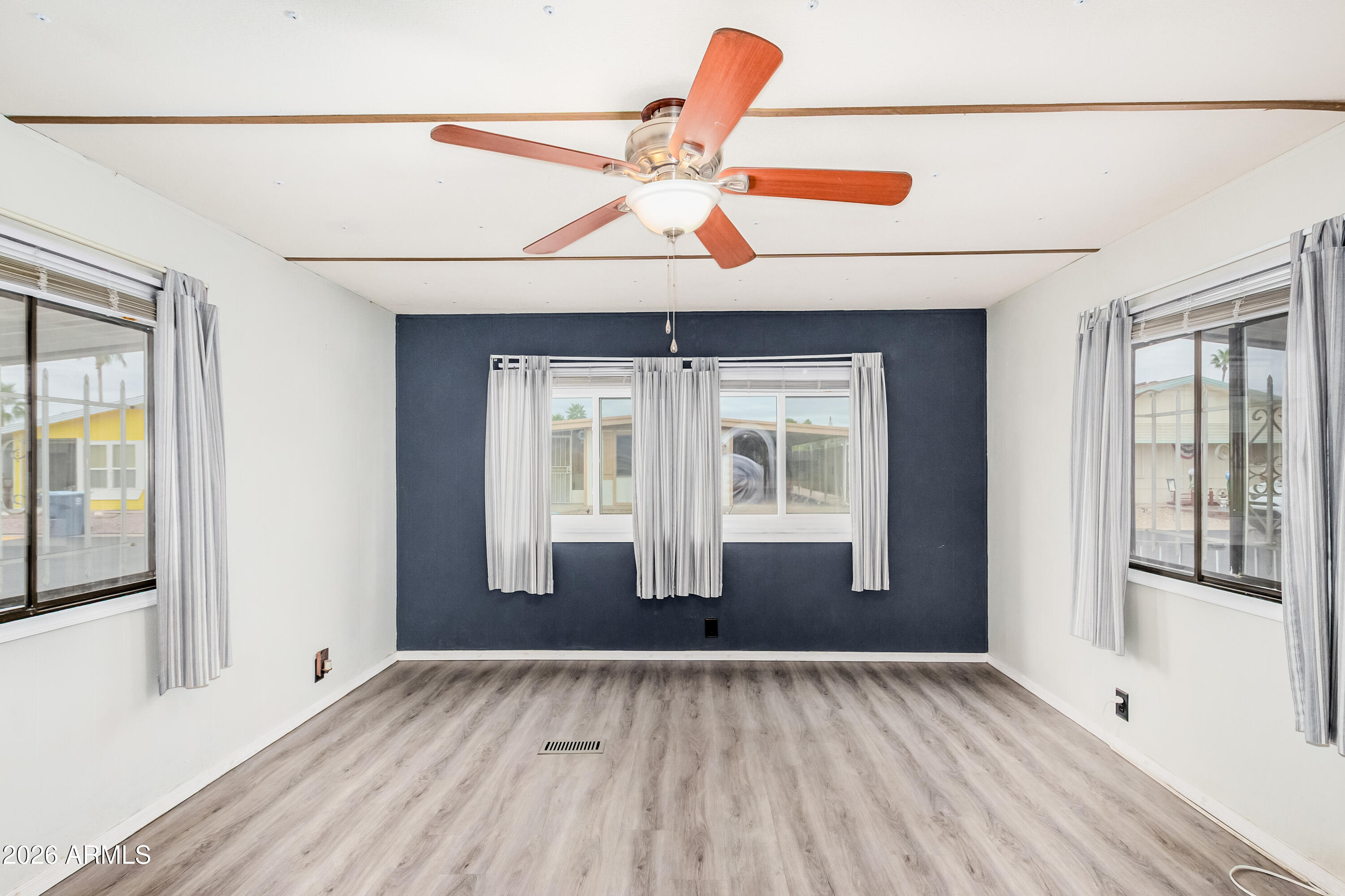 9302 East Broadway Road, Unit 122 Mesa, AZ 85208 - Photo 7 of 30 a view of wooden floor and a chandelier fan in a room
