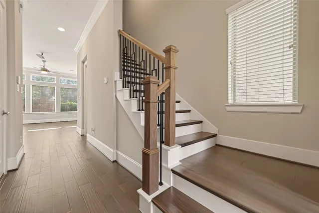 an empty room with ceiling fan and windows