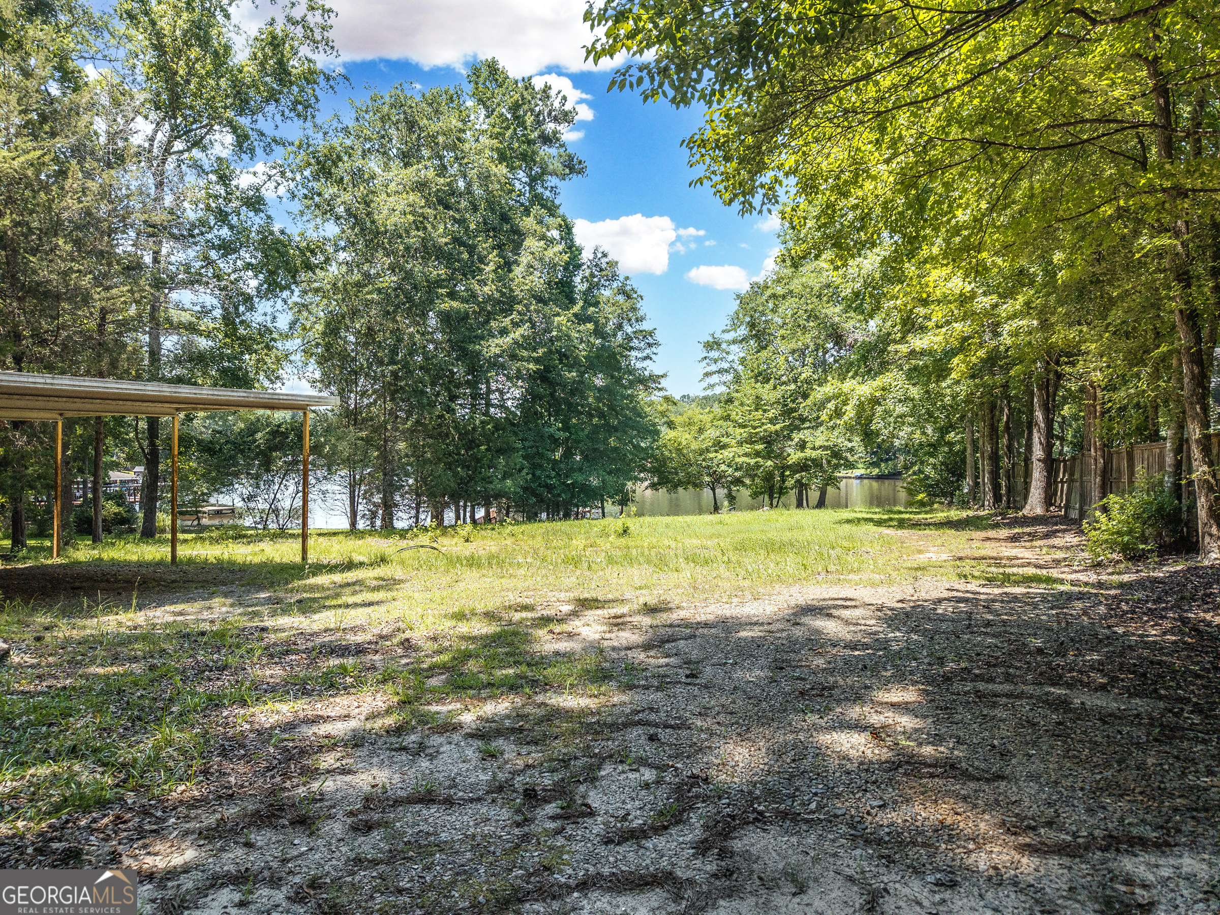 909 South Steel Bridge Road Eatonton, GA 31024 - Photo 7 of 18 a view of a swimming pool with a yard and large trees