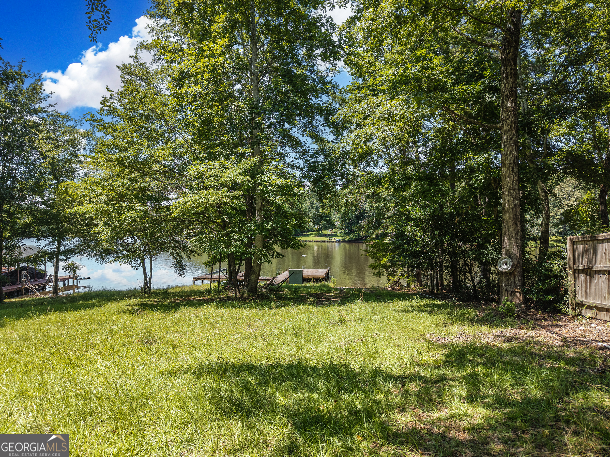 909 South Steel Bridge Road Eatonton, GA 31024 - Photo 10 of 18 a view of swimming pool with lawn chairs and large trees