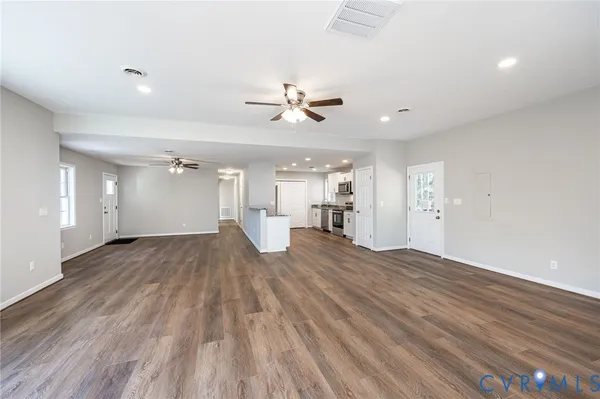a view of a room with a ceiling fan hardwood floor and a ceiling fan