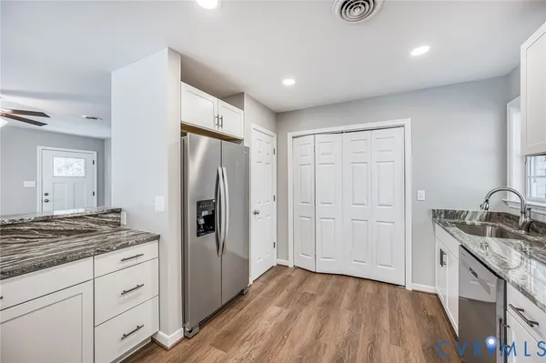 a kitchen with granite countertop a sink stove and refrigerator