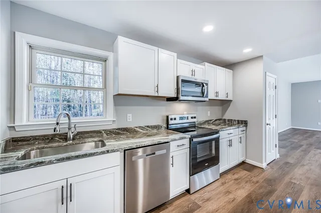 a kitchen with stainless steel appliances granite countertop a refrigerator and a stove