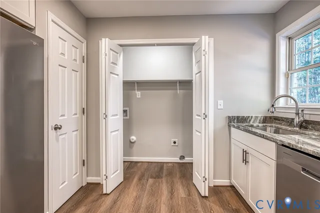 an empty room with wooden floor chandelier fan and windows