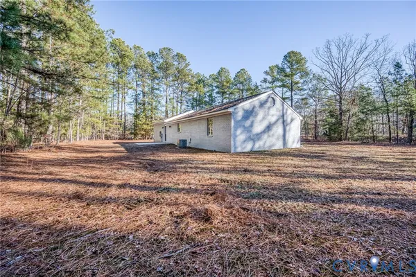 a view of a house with backyard and trees