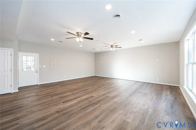 a view of a room with a ceiling fan hardwood floor and a ceiling fan