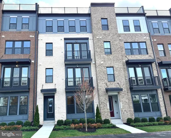 a front view of a brick building next to a yard