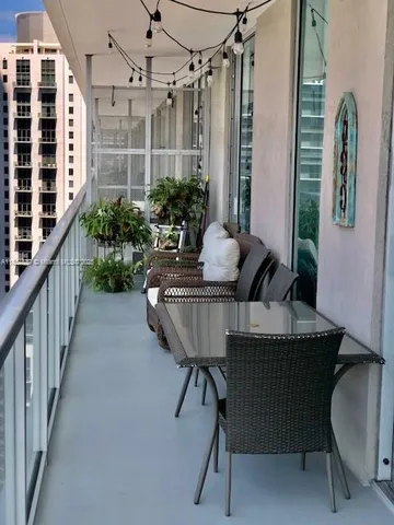 a balcony with table and chairs