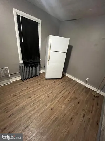 a view of a room with wooden floor and cabinet