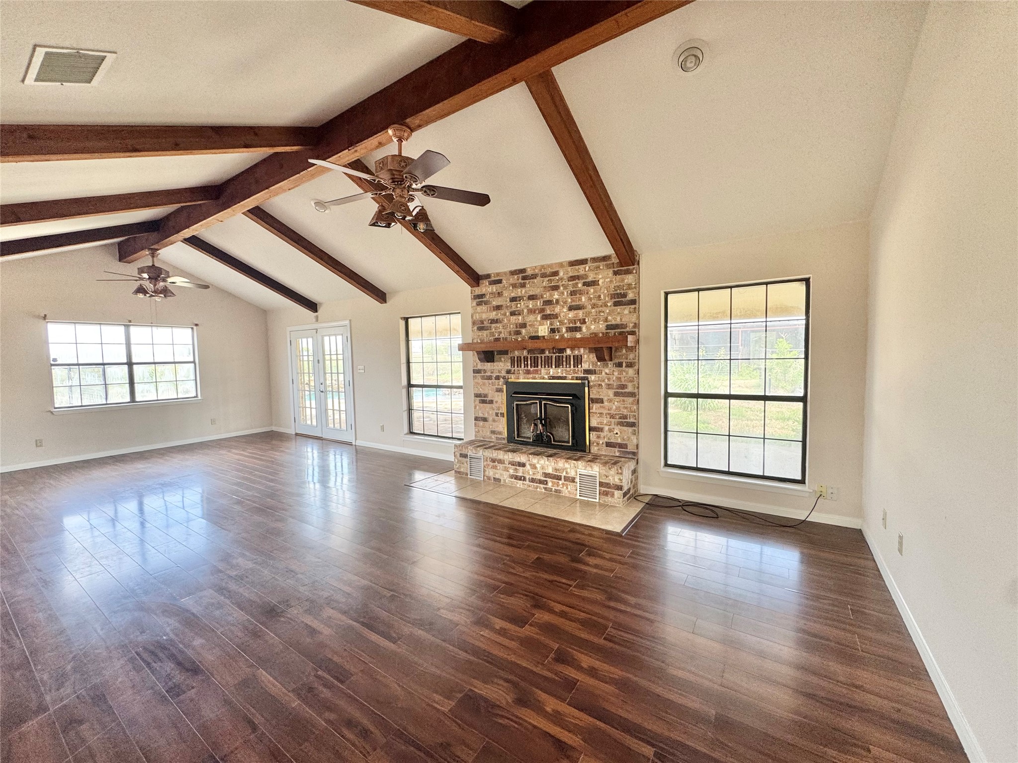 18512 Carlson Lane Elgin, TX 78621 - Photo 3 of 29 A classic brick fireplace Anchors this living space beneath high vaulted and beamed ceilings.