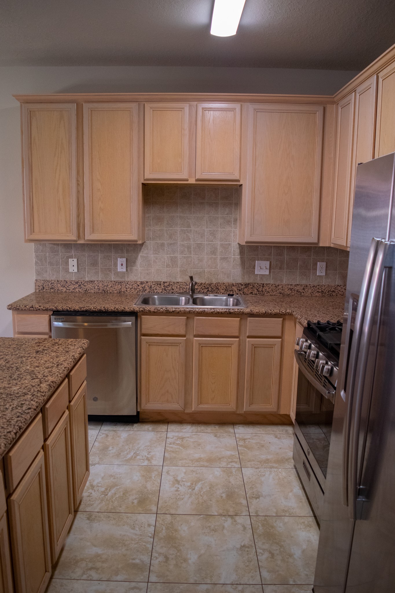 9224 Rodney Ray Boulevard, Unit 18 Houston, TX 77040 - Photo 17 of 27 a kitchen with a stove top oven sink and cabinets