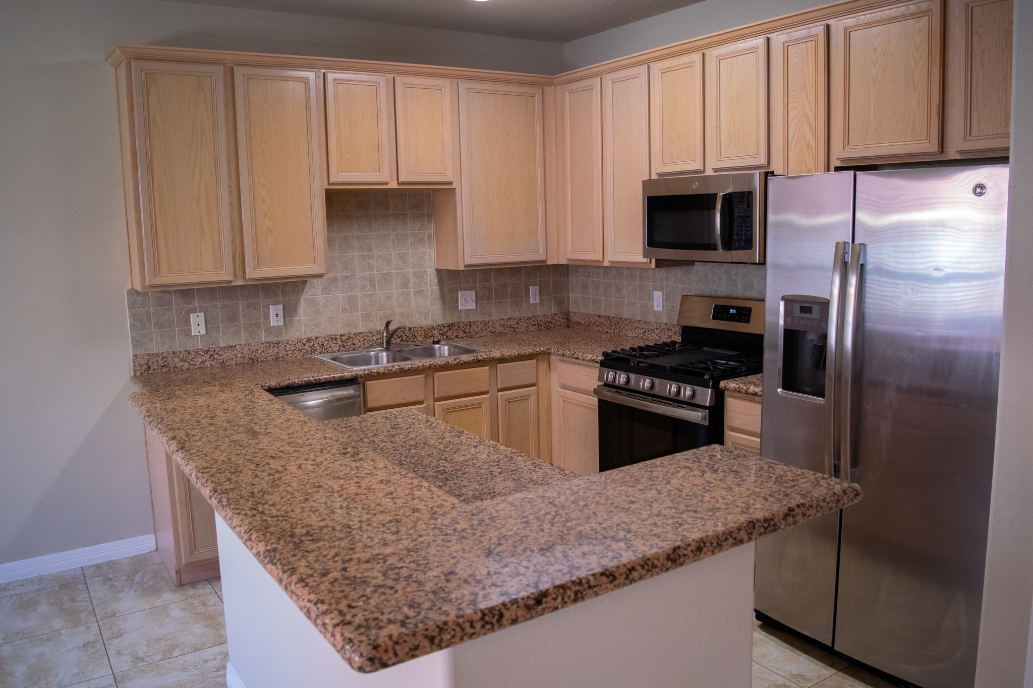 9224 Rodney Ray Boulevard, Unit 18 Houston, TX 77040 - Photo 18 of 27 a kitchen with stainless steel appliances granite countertop a sink stove and refrigerator