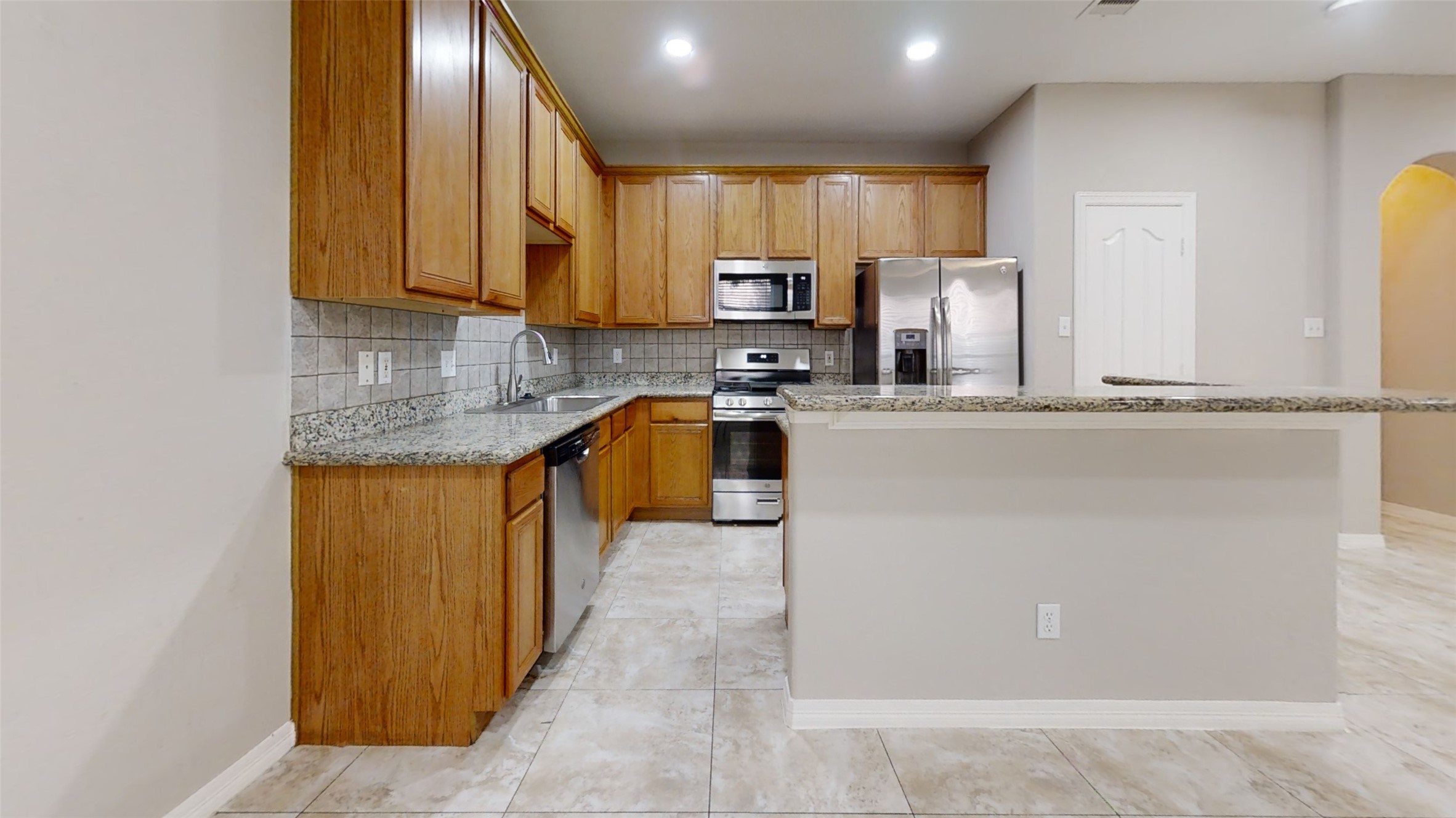 9224 Rodney Ray Boulevard, Unit 18 Houston, TX 77040 - Photo 4 of 27 a kitchen with stainless steel appliances granite countertop wooden cabinets a stove top oven a sink and dishwasher