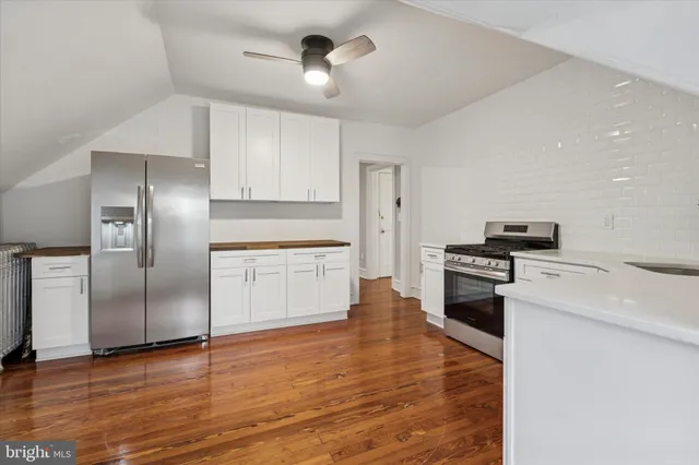 a kitchen with granite countertop a refrigerator and a stove top oven