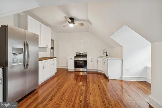 a kitchen with wooden floors and refrigerator