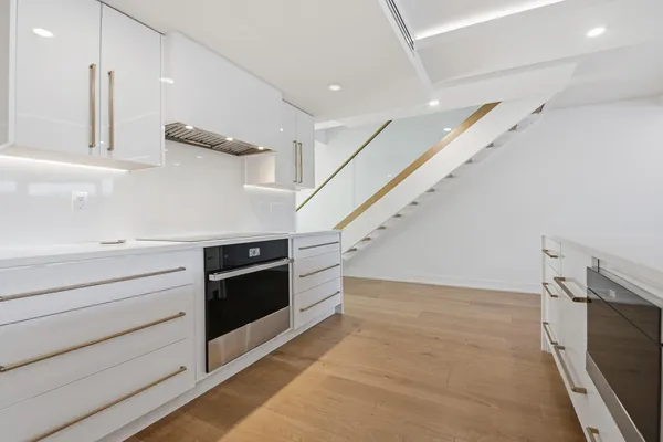 a large kitchen with stainless steel appliances and white cabinets