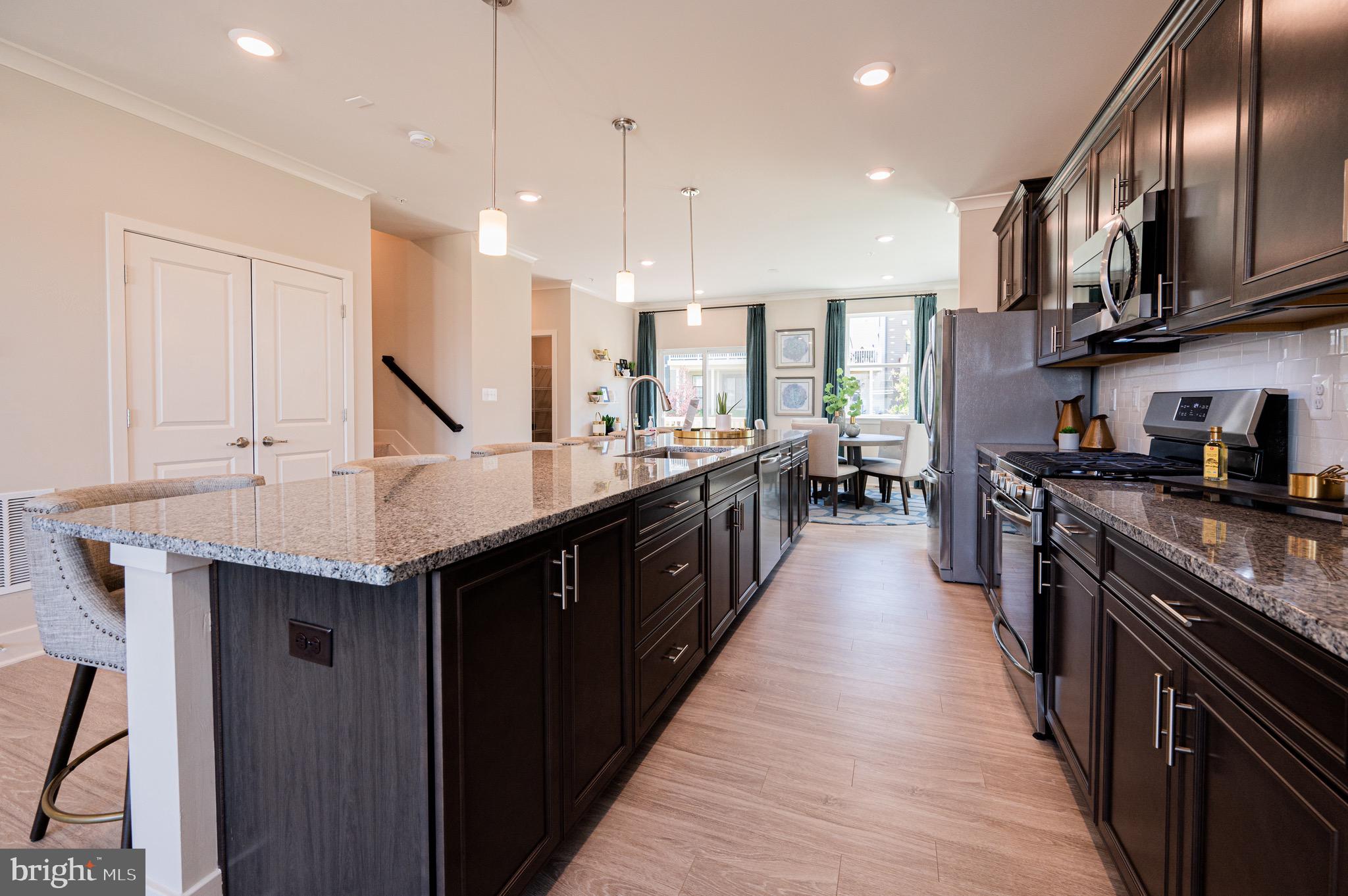 7209 Paper Way Glen Burnie, MD 21060 - Photo 16 of 40 a kitchen with stainless steel appliances granite countertop a sink a stove top oven a counter space and cabinets