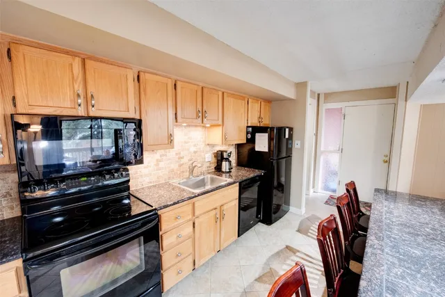a kitchen with stainless steel appliances granite countertop a stove a sink and a refrigerator