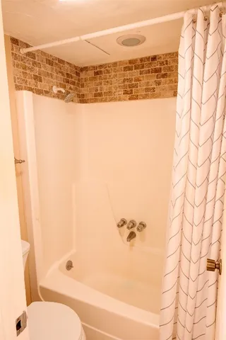 a bathroom with a bathtub and shower
