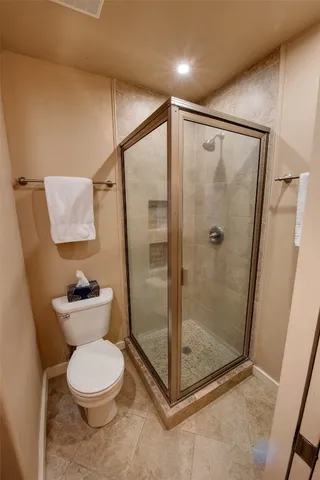 a bathroom with a toilet and a shower