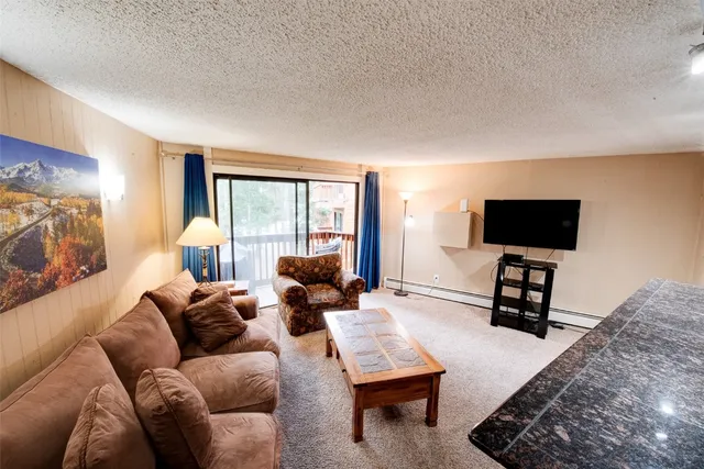 a living room with furniture a flat screen tv and a window