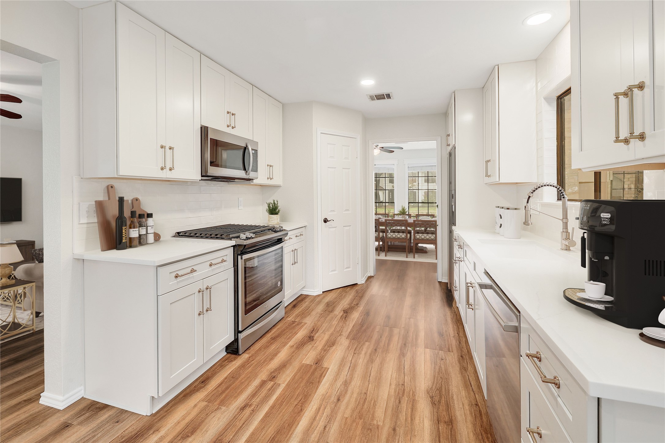 409 Cedar Mound Pass Cedar Park, TX 78613 - Photo 7 of 18 a kitchen with stainless steel appliances a stove top oven a sink a refrigerator white cabinets and wooden floor