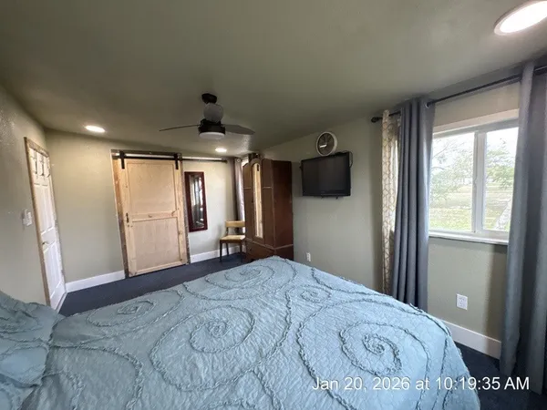a bedroom with a bed and a large mirror