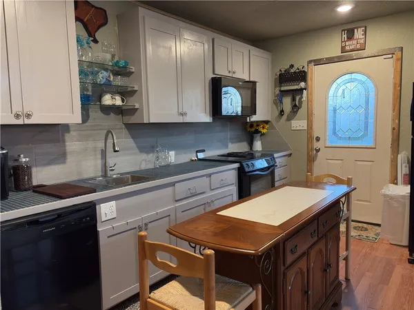 a kitchen with granite countertop a sink stainless steel appliances and cabinets
