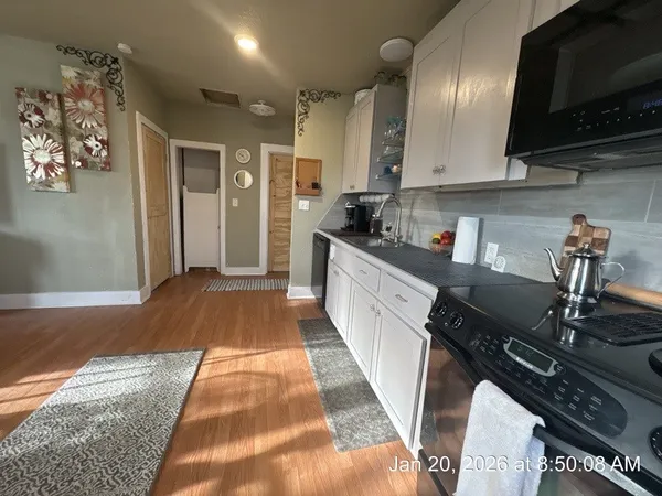 a kitchen with stainless steel appliances granite countertop a stove a sink and a microwave