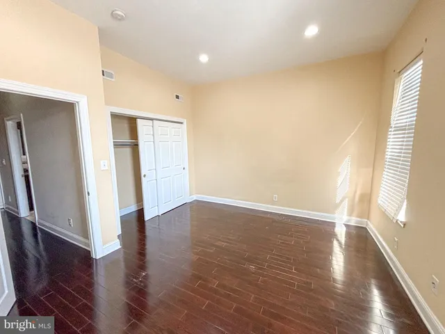 an empty room with wooden floor and a window