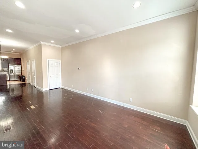 a view of a room with wooden floor and a large window