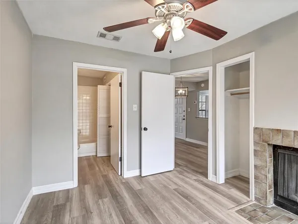 wooden floor in an empty room with a chandelier fan